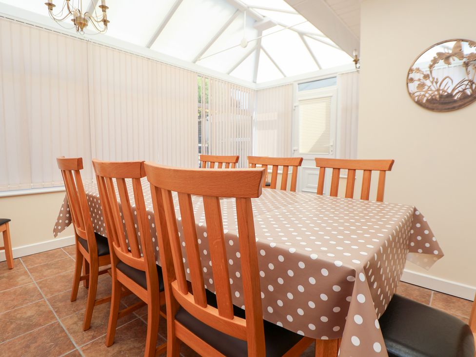 A dining room with a table and chairs at Bryn Bach in Rhos-On-Sea