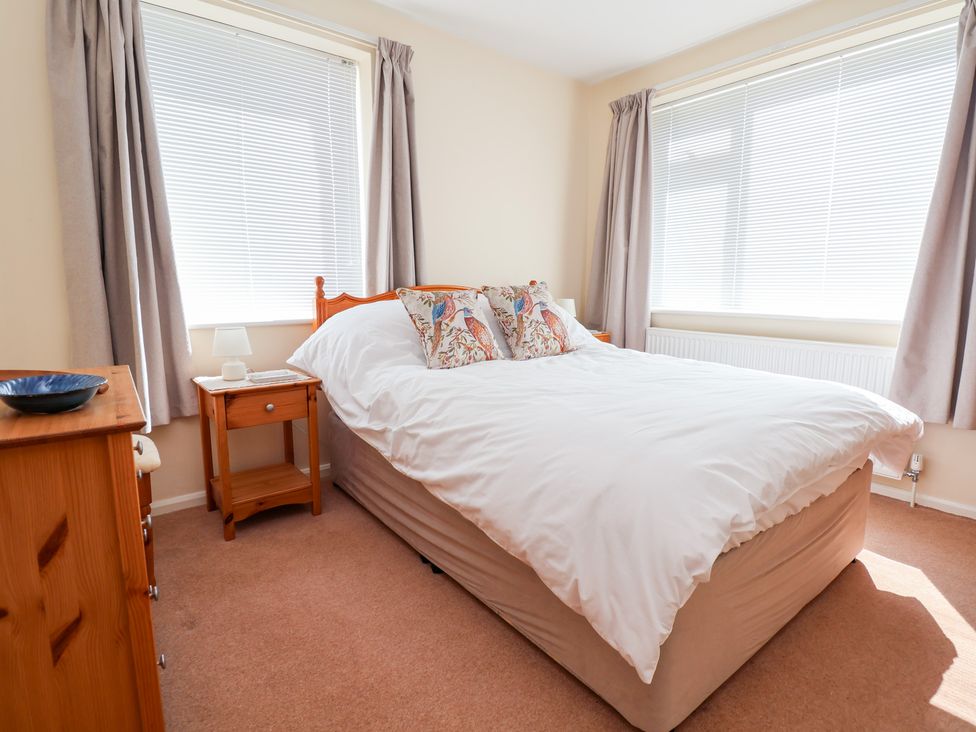 A bedroom with a bed and bedside table at Bryn Bach in Rhos-On-Sea