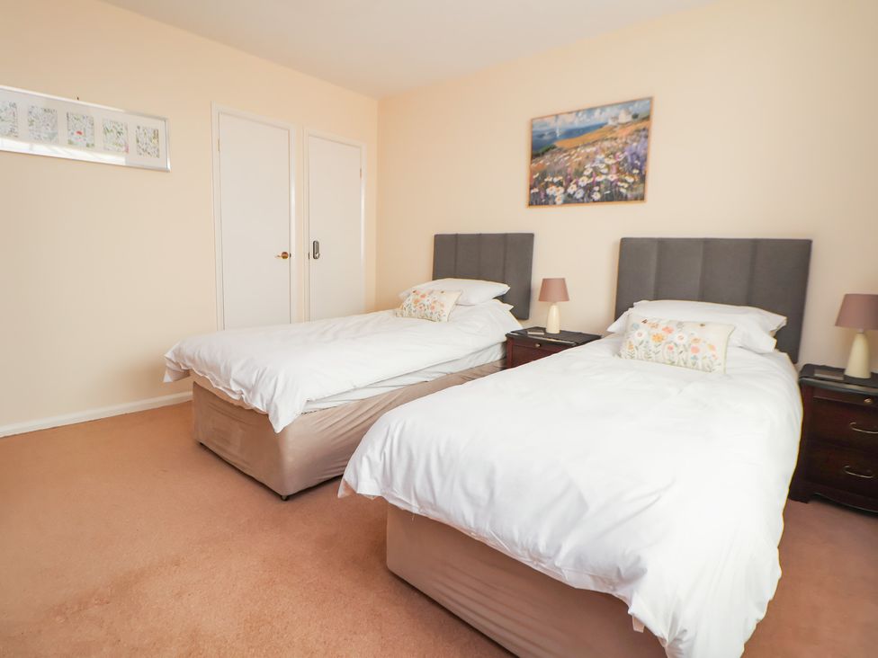 A bedroom with two beds and a painting at Bryn Bach in Rhos-On-Sea