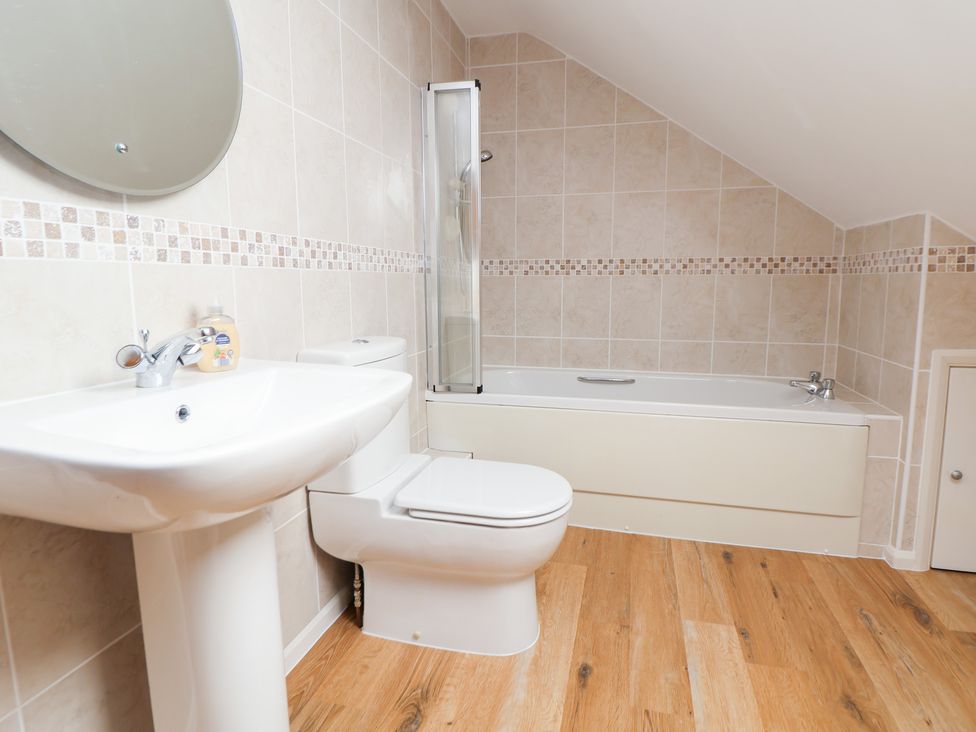 A bathroom with a sink, toilet, and bathtub at Bryn Bach in Rhos-On-Sea