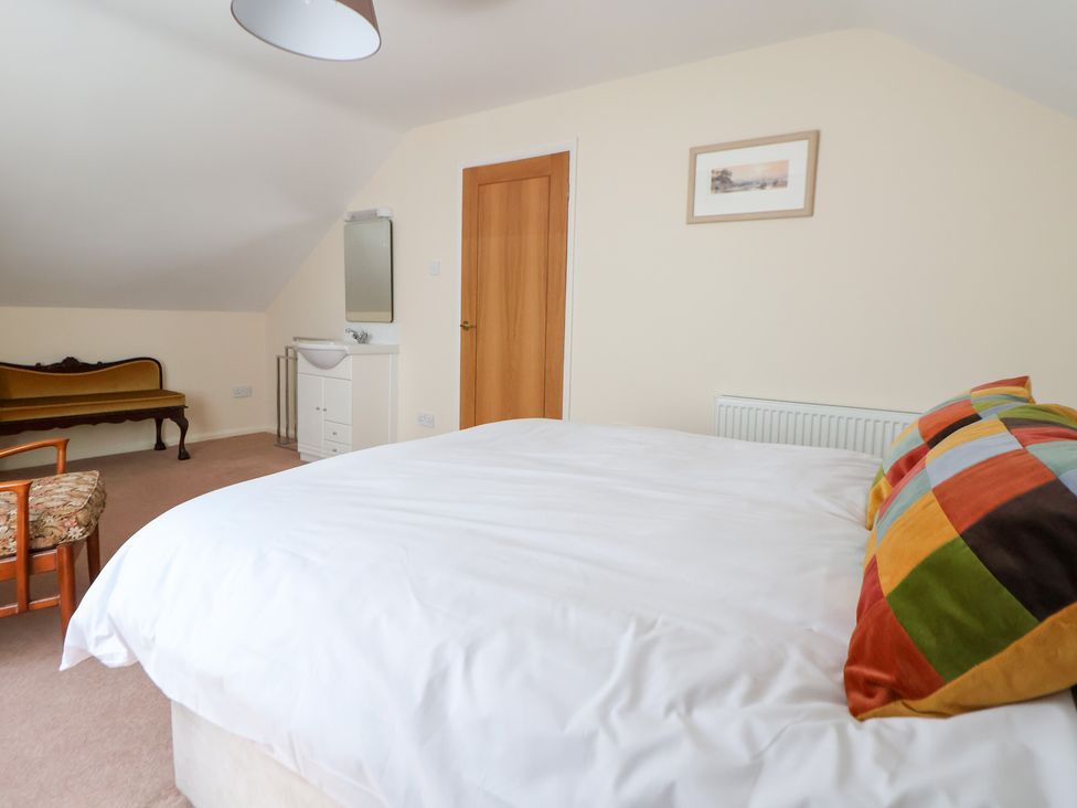 A bedroom with a bed and a wardrobe at Bryn Bach in Rhos-On-Sea