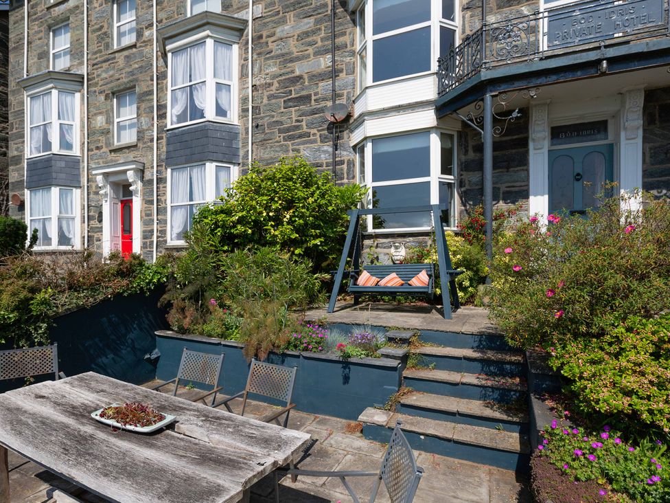 An outdoor area with a swing and garden at Bod Idris in Barmouth