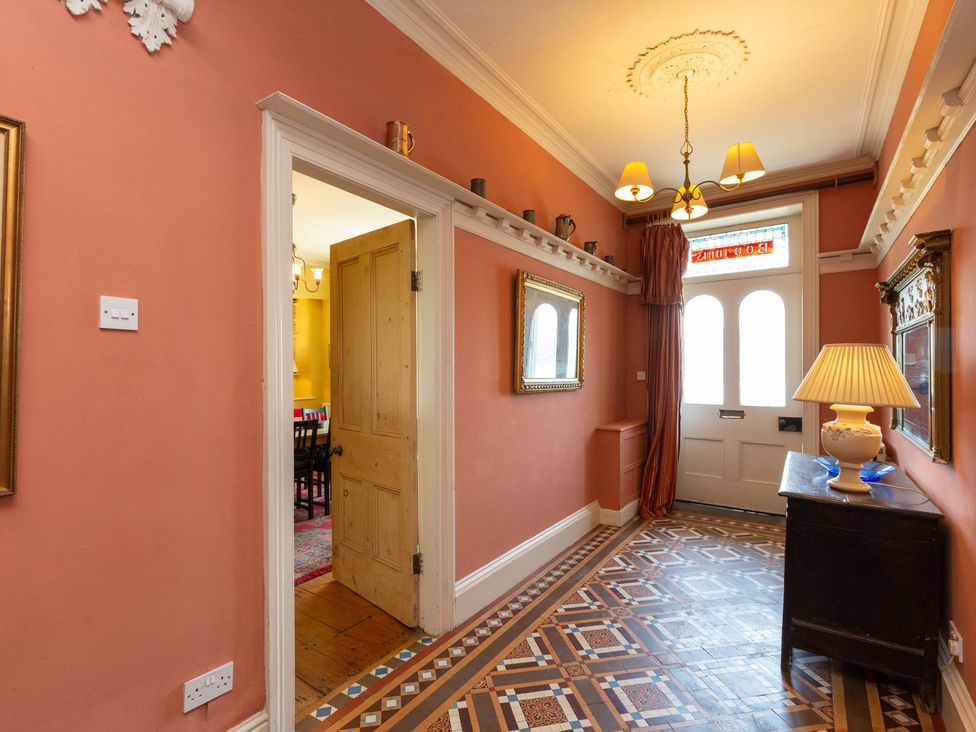 A hallway with a lamp and mirror at Bod Idris in Barmouth