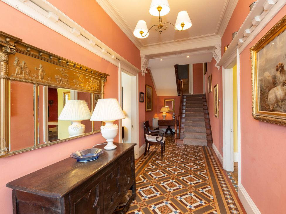 A hallway with stairs and decorative items at Bod Idris in Barmouth
