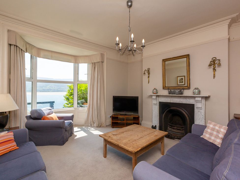 A living room with a sofa, chairs, and a coffee table at Bod Idris in Barmouth