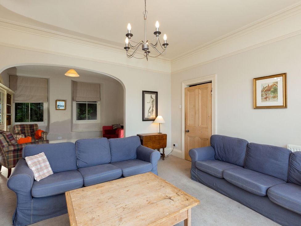 A living room with a sofa and wooden table at Bod Idris in Barmouth