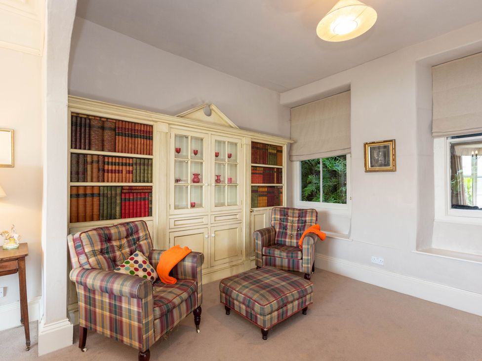 A sitting room with armchairs and a bookshelf at Bod Idris in Barmouth
