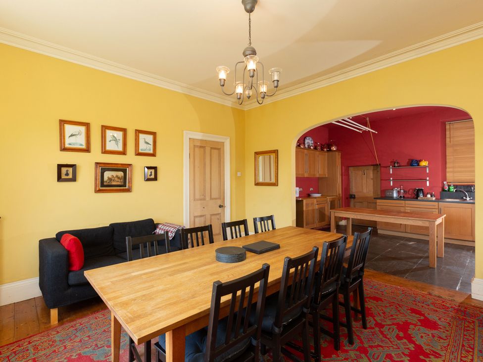 A dining room with a wooden table and chairs at Bod Idris in Barmouth