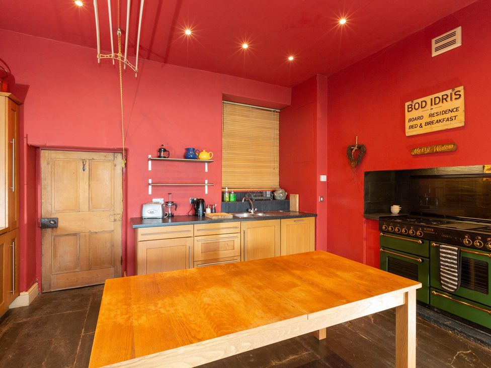A kitchen with a table and appliances at Bod Idris in Barmouth