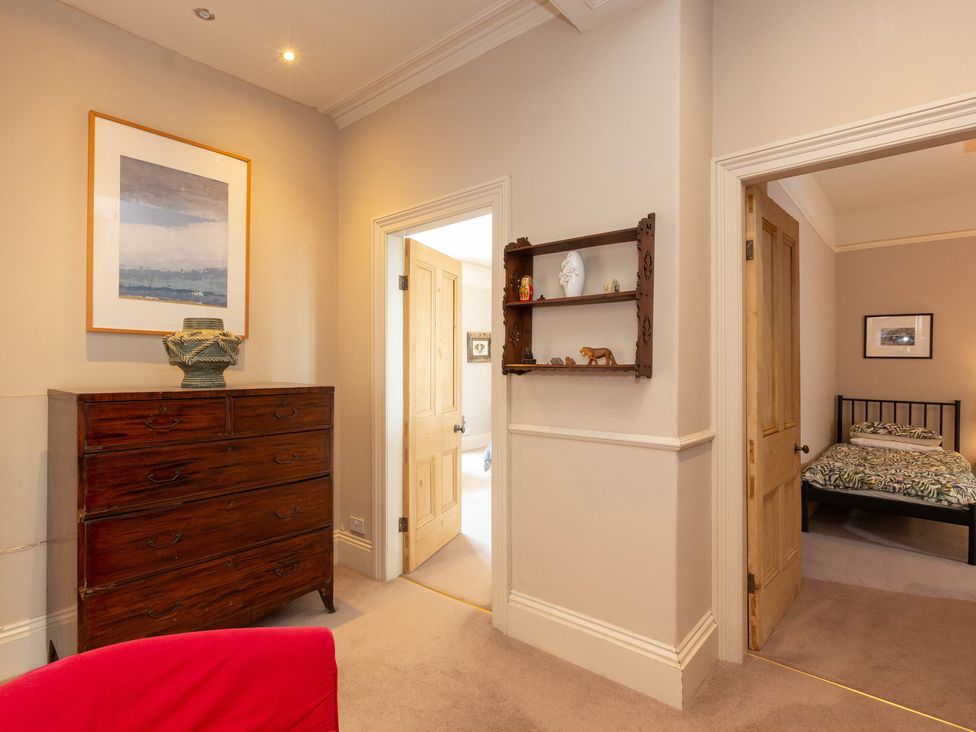 A hallway with a dresser and shelf at Bod Idris in Barmouth
