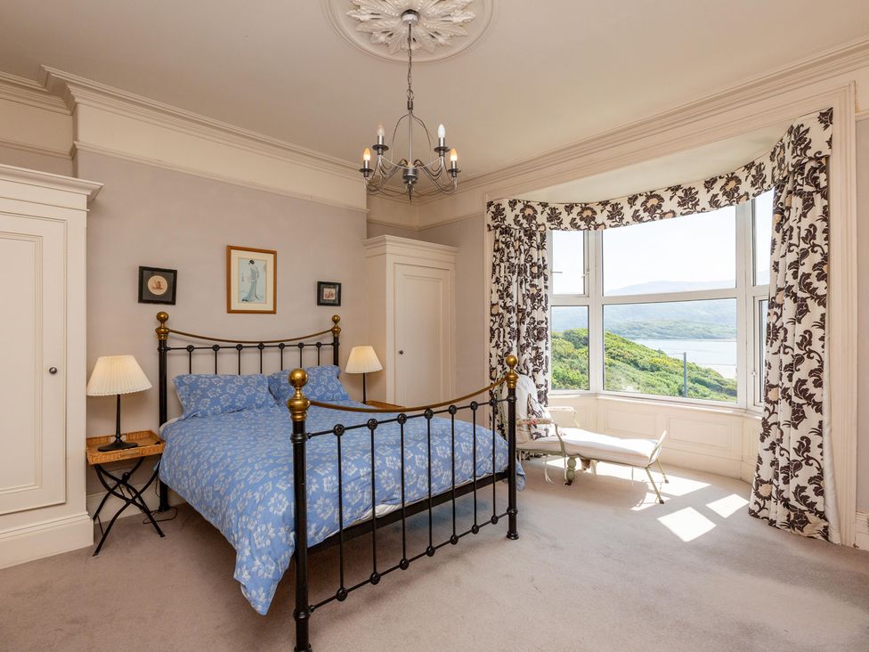 A bedroom with a bed and window overlooking the landscape at Bod Idris in Barmouth
