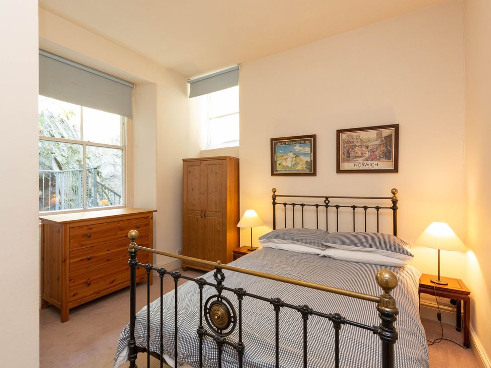 A bedroom with a bed, wardrobe, and chest of drawers at Bod Idris in Barmouth