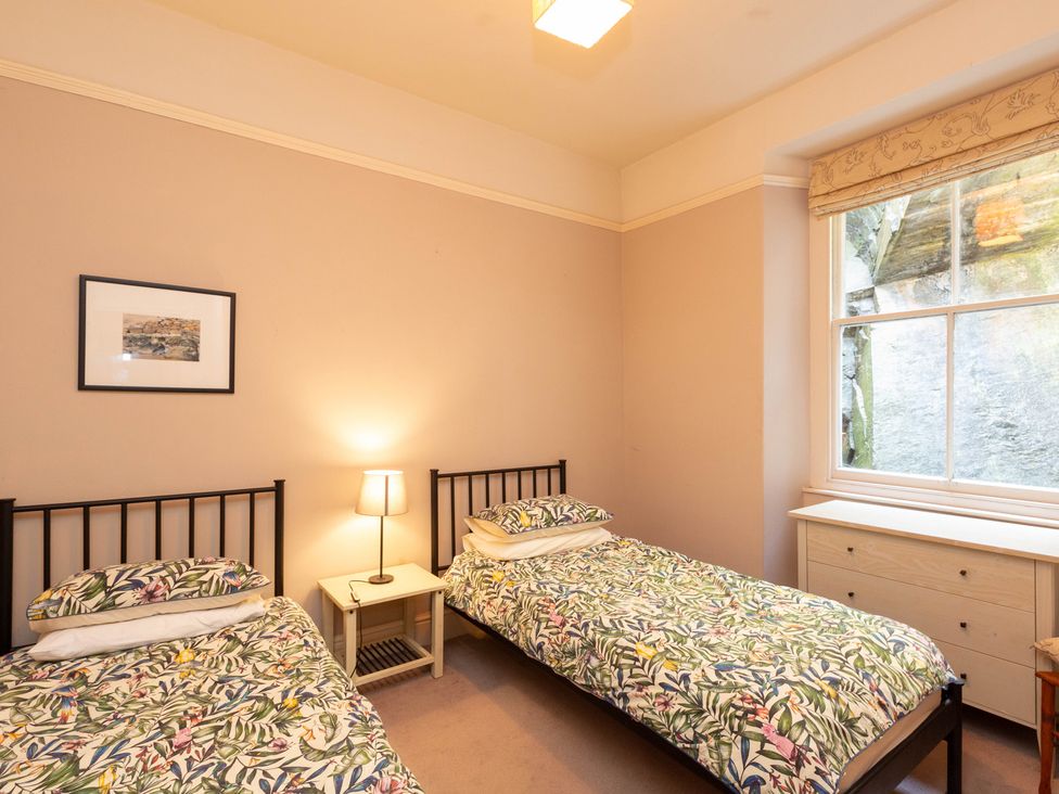A bedroom with two beds and a dresser at Bod Idris in Barmouth
