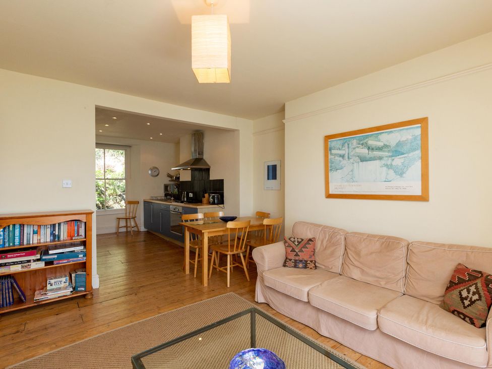 A living room with a sofa and a dining area at Bod Idris in Barmouth