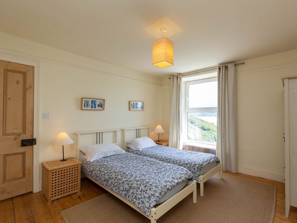 A bedroom with two twin beds and a window at Bod Idris in Barmouth