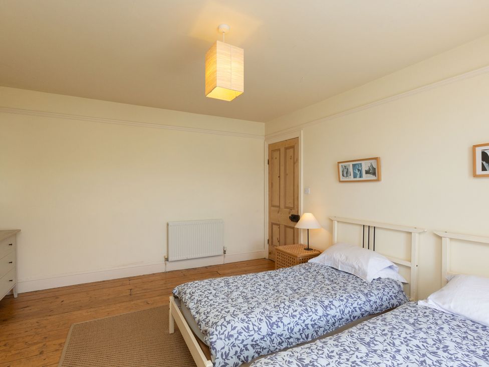 A bedroom with two single beds and a lamp at Bod Idris in Barmouth