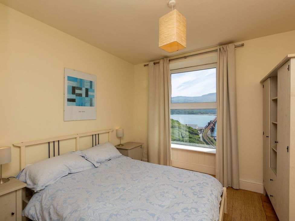 A bedroom with a bed and nightstand at Bod Idris in Barmouth