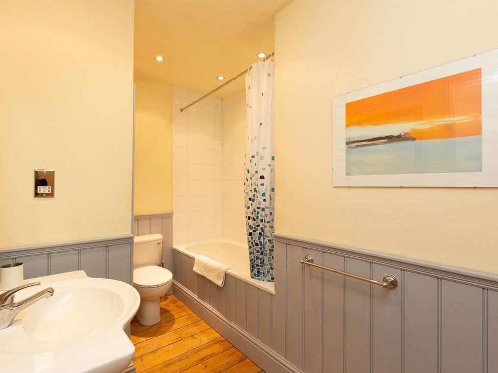 A bathroom with a bathtub, toilet, and sink at Bod Idris, Barmouth