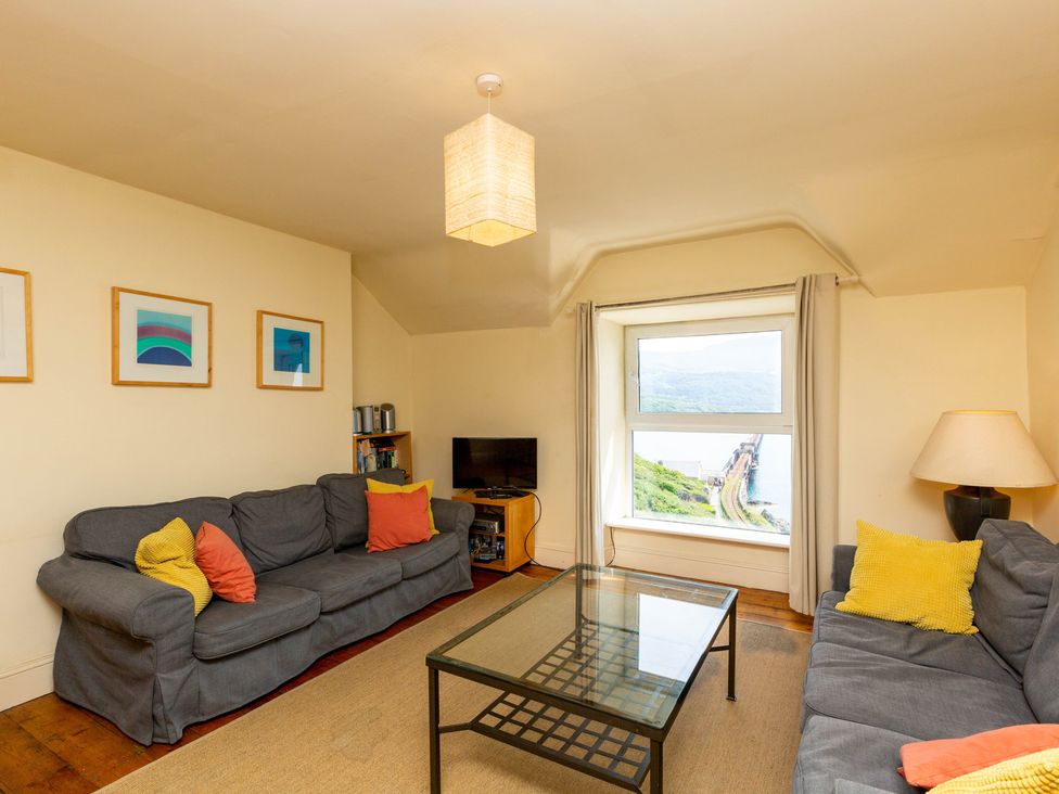 A living room with a sofa and table at Bod Idris in Barmouth