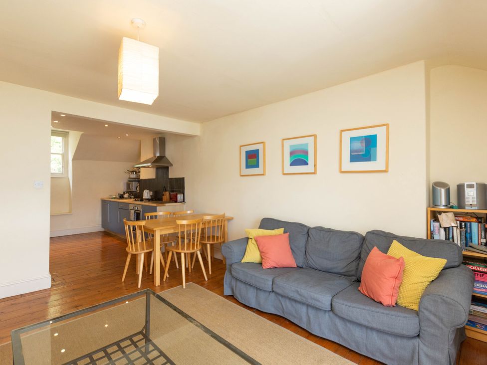 A living room with a sofa and dining table at Bod Idris in Barmouth