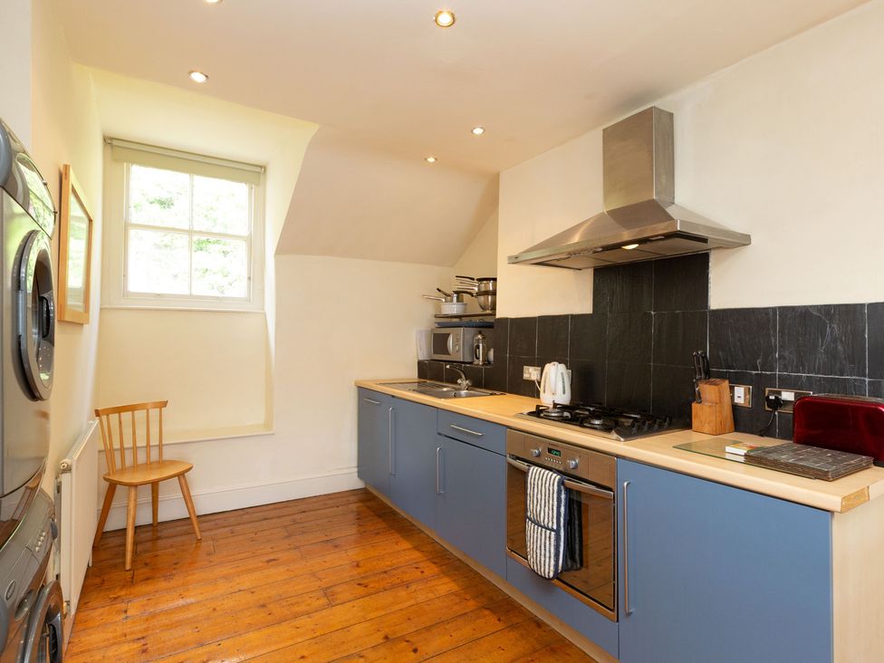 A kitchen with appliances and a chair at Bod Idris in Barmouth