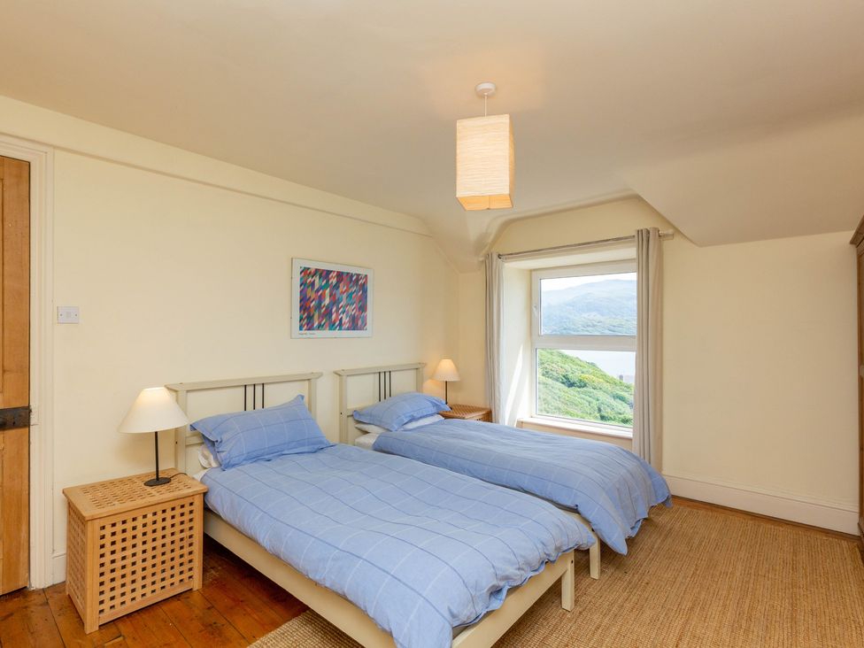 A bedroom with two beds and a window at Bod Idris in Barmouth