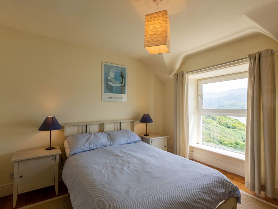 A bedroom with a bed and bedside tables at Bod Idris in Barmouth