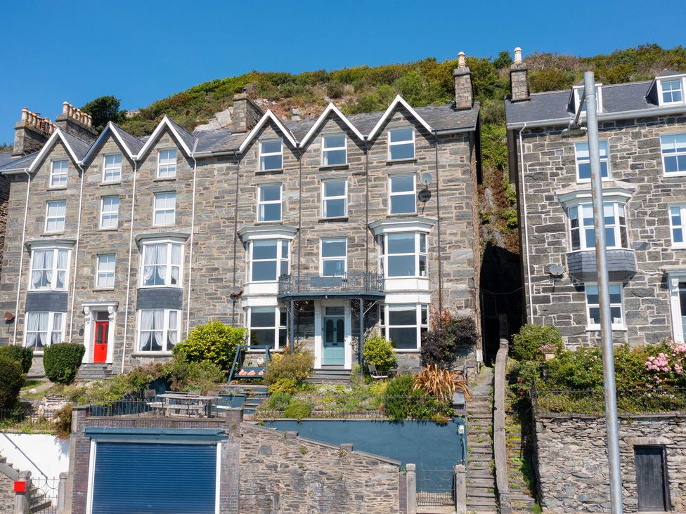 A stone building with multiple windows and a door at Bod Idris in Barmouth