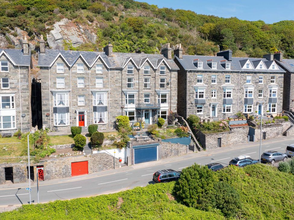 A row of buildings with gardens and cars parked at Bod Idris in Barmouth