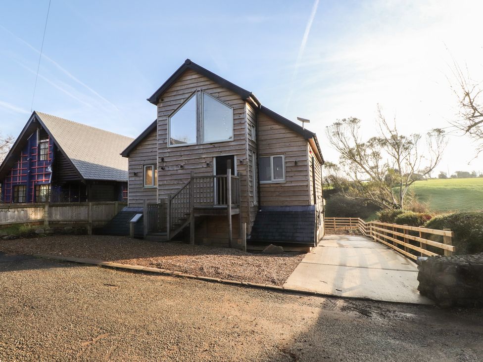 A modern house with a wooden exterior and a driveway at The Hideaway in 