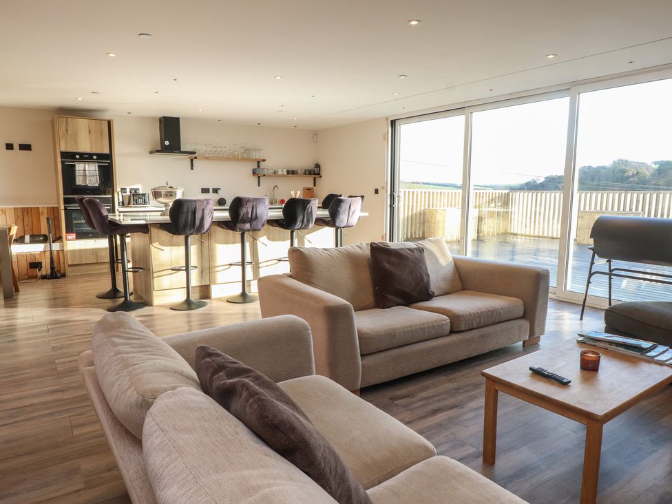 A living room with a sofa and kitchen area at The Hideaway in 