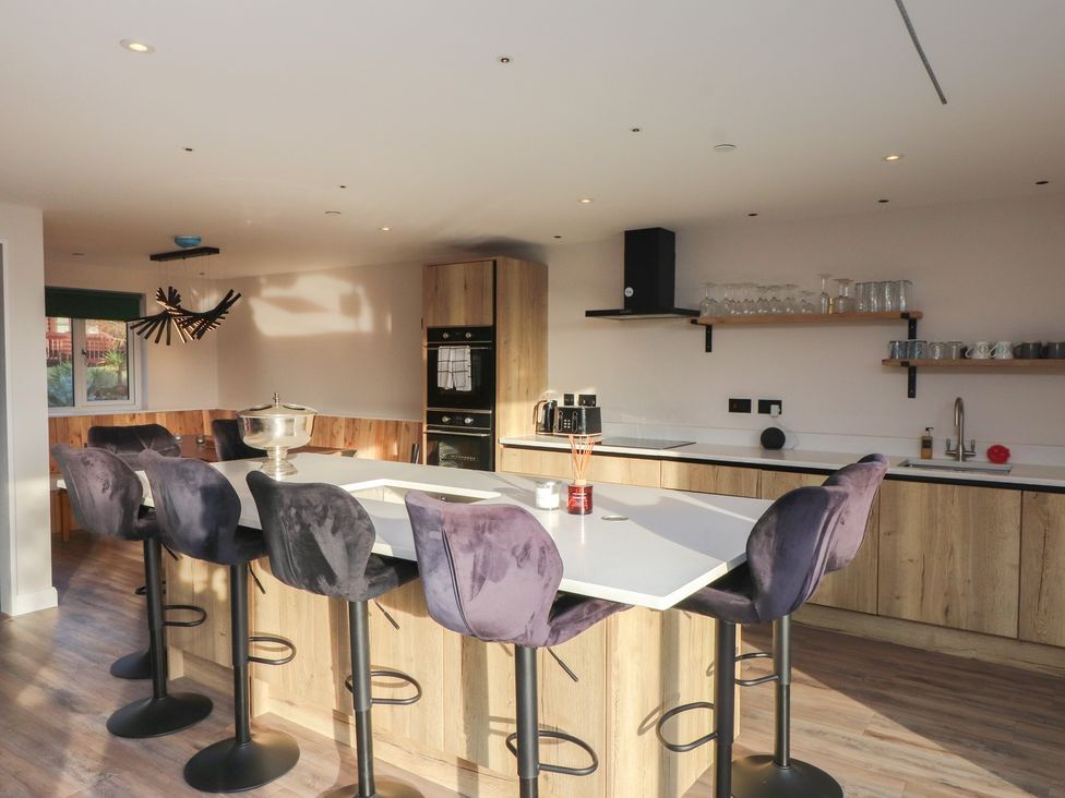 A modern kitchen with an island and bar stools at The Hideaway
