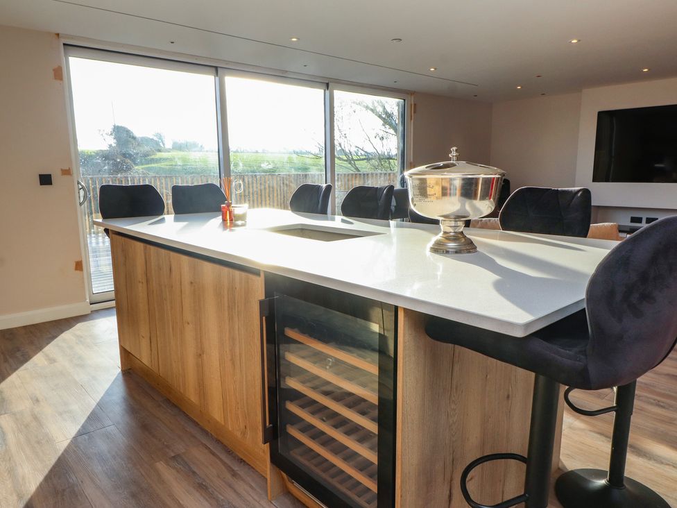 A kitchen with an island and bar stools at The Hideaway