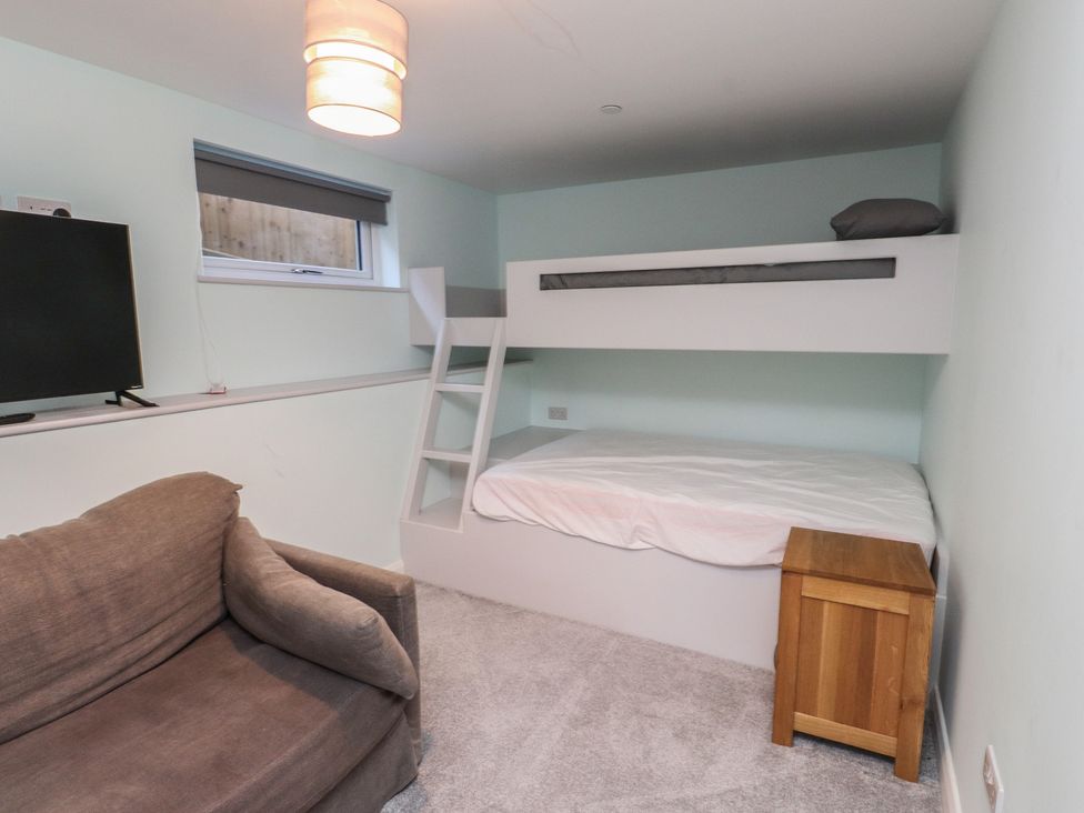 A bedroom with a bunk bed and a sofa at The Hideaway