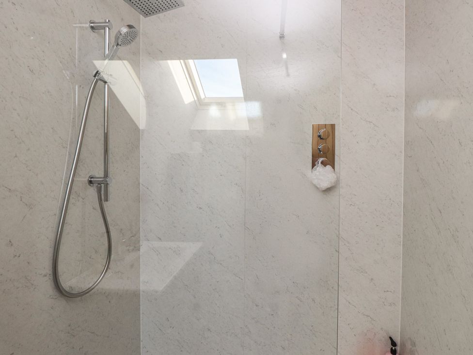 A shower area with a shower head and control panel at The Hideaway