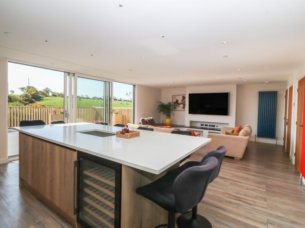 A living room with a kitchen island and sofa at The Hideaway in Mynytho near Abersoch