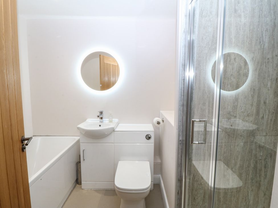 A bathroom with a bathtub, shower, sink, and toilet at The Hideaway in Mynytho near Abersoch