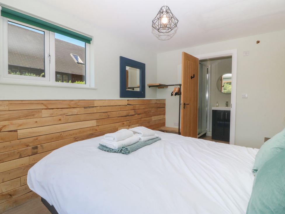 A bedroom with a bed and an adjoining bathroom at The Hideaway Mynytho near Abersoch