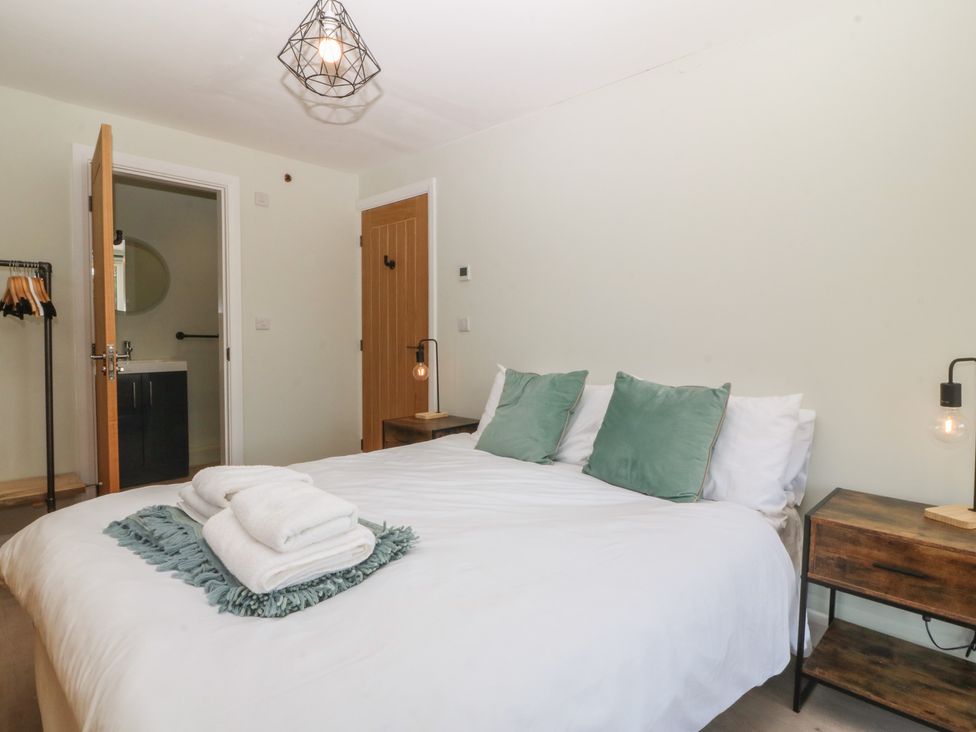 A bedroom with a bed and lamp at The Hideaway in Mynytho near Abersoch
