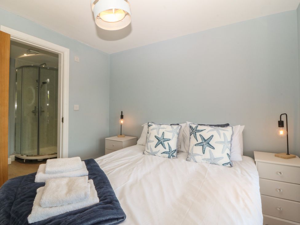 A bedroom with a bed and a shower at The Hideaway in Mynytho near Abersoch
