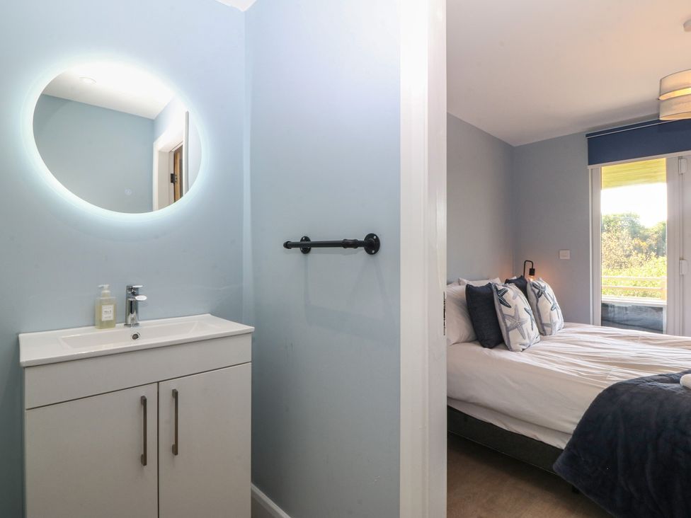 A bedroom with a double bed and a vanity area at The Hideaway in Mynytho near Abersoch