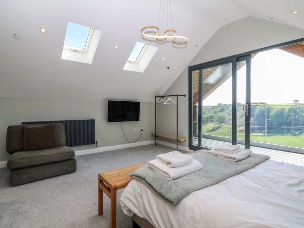 A bedroom with a bed and a TV at The Hideaway in Mynytho near Abersoch