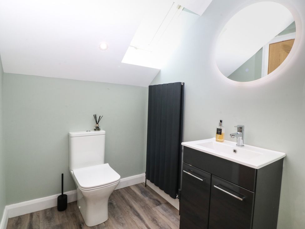 A bathroom with a toilet, vanity unit, and sink at The Hideaway in Mynytho near Abersoch
