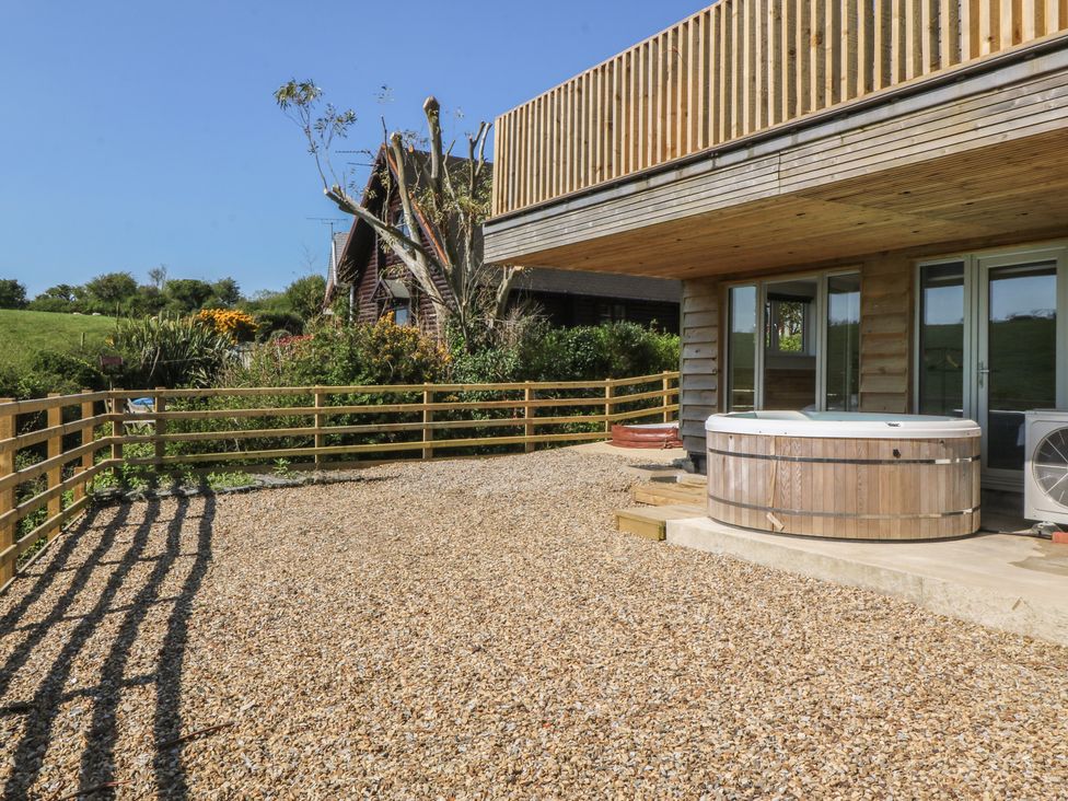 An outdoor area with a hot tub and fence at The Hideaway in Mynytho near Abersoch