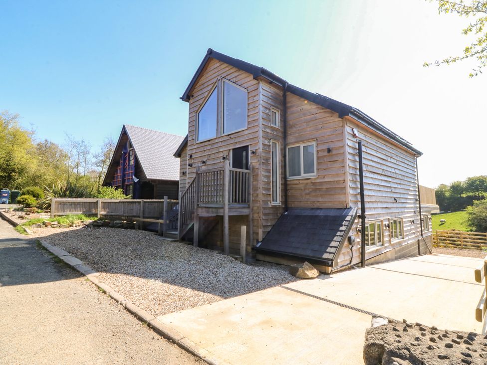 A wooden house with a gravel driveway and steps at The Hideaway in Mynytho near Abersoch