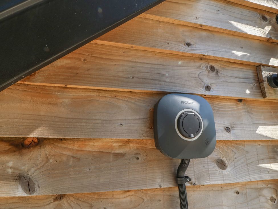 An EV charger mounted on a wooden wall at The Hideaway in Mynytho near Abersoch