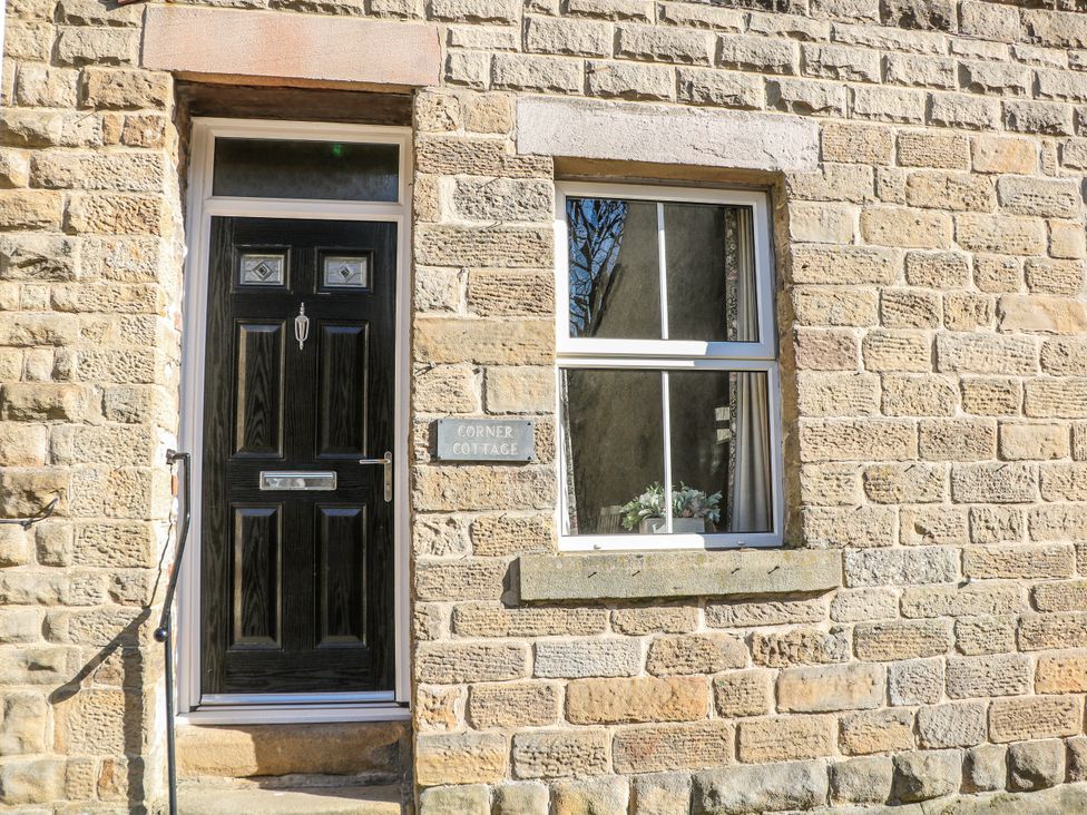 The entrance with a black door and a window at Corner Cottage in Tideswell