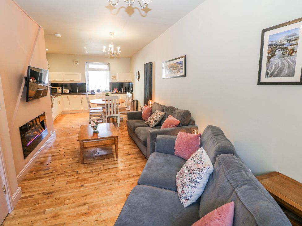 A living room with sofas and a dining area at Corner Cottage in Tideswell