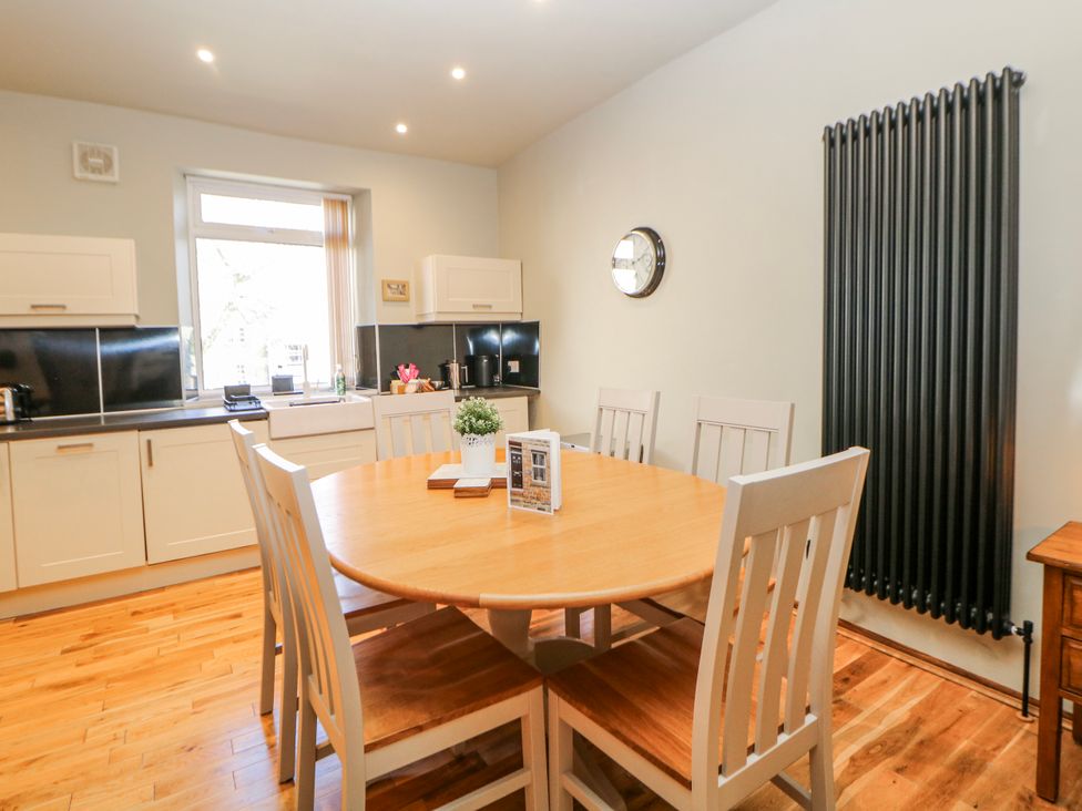 A kitchen with a dining table and chairs at Corner Cottage in Tideswell