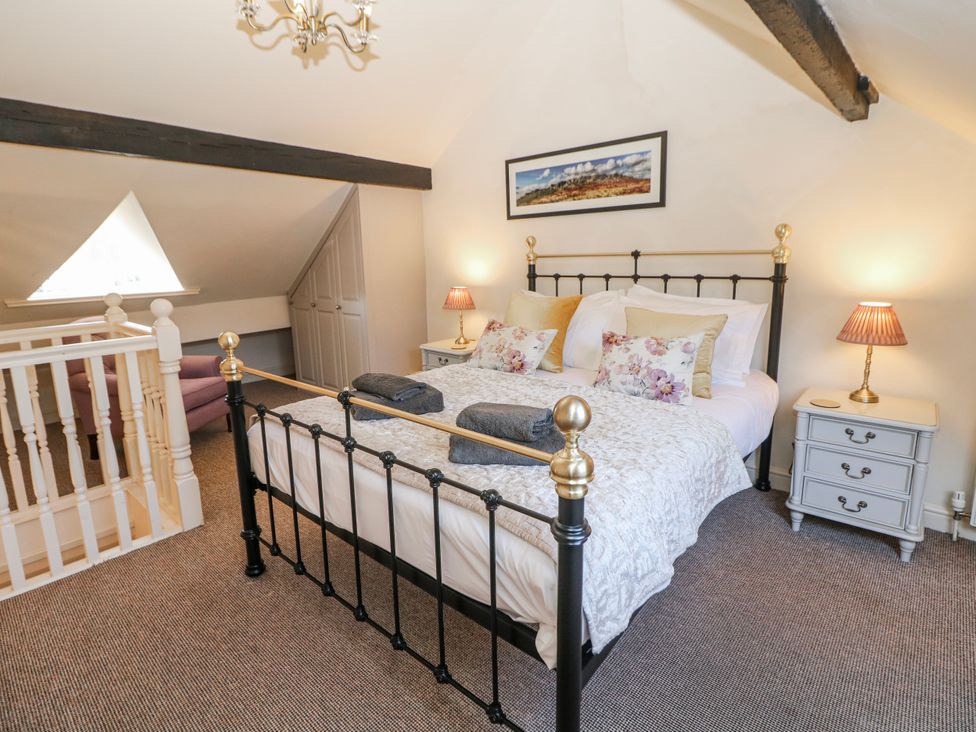 A bedroom with a bed and bedside tables at Corner Cottage in Tideswell